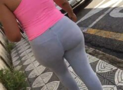 Mujer con curvas usando mallas ajustadas en sus glúteos en la calle