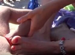 Disfrutar de un masaje en los pies de una mujer mayor en la playa