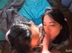 Dos mujeres asiáticas practicando sexo oral con dos hombres en un encuentro íntimo